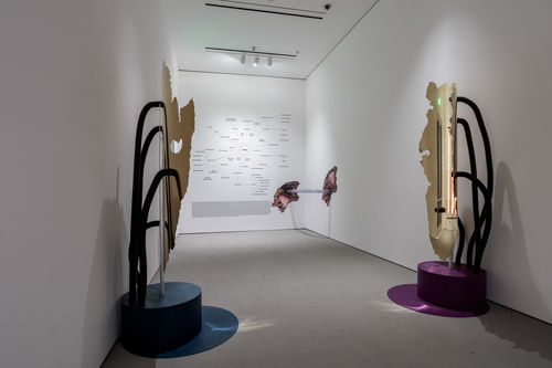 Gallery space with 2 tall sculptures.