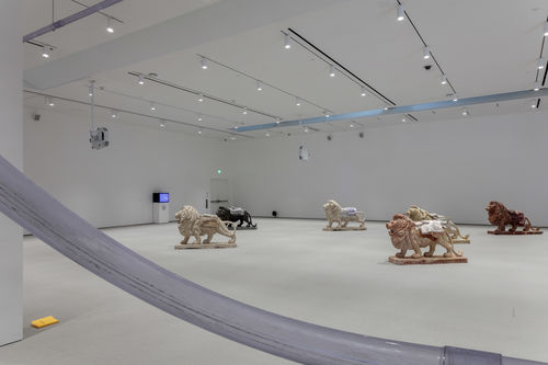 6 roaring lion sculptures in a gallery space.