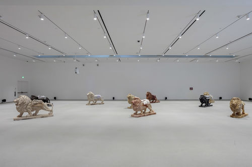 6 roaring lion sculptures in a gallery space.