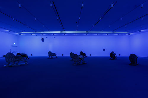 Lion sculptures in a dark room with blue light.