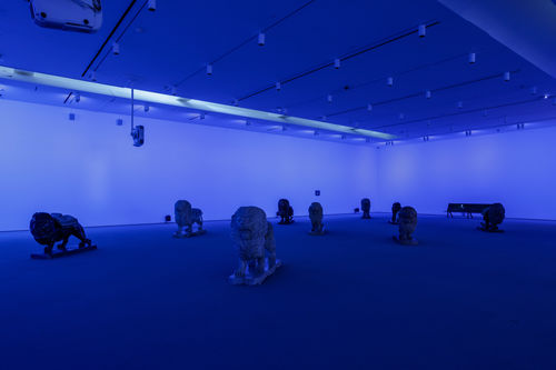Lion sculptures in a dark room with blue light.