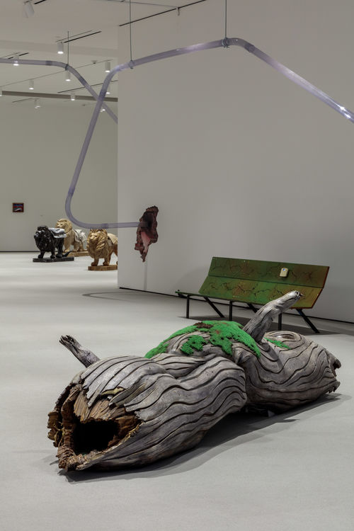 Gallery space centering on log sculpture.