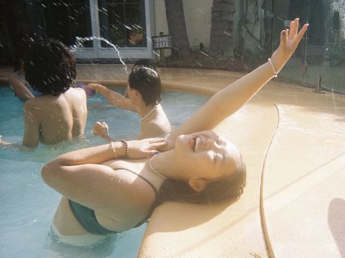 A girl is in a swimming pool very happy.