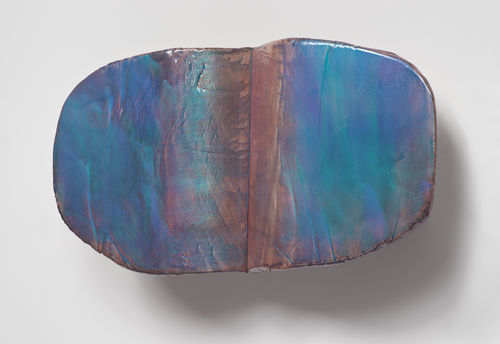 An organic sculptural shape in rust and turquoise hues