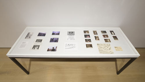 Photo of a table covered in archival photographs and other documents related to Ulysses Jenkins artwork