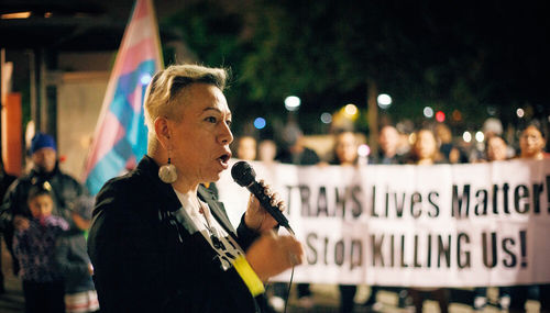 Photo of Bamby Salcedo speaking into a microphone at a trans rights march
