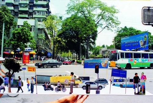 Hand holding a collage of a busy cityscape with Motorola ads