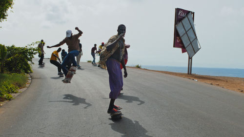 Men skate down hill