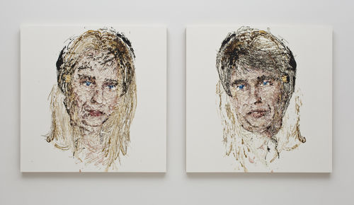 Two side-by-side paintings of a man's and a woman's face painted over each other