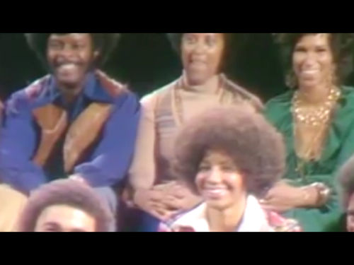 View of an audience of smiling Black men and women, apparently from the 70s