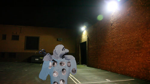 A cartoon man wearing a shirt covered in eyes holds a pair of scissors