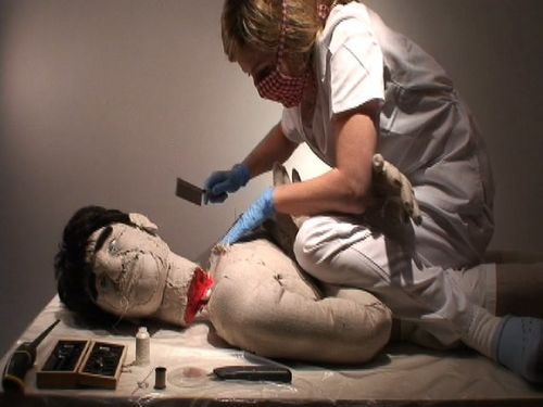 The artist decapitates a dummy with a butcher knife