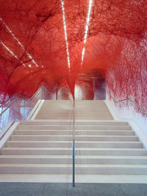 Installation view of Chiharu Shiota's installation enveloping the museum lobby in a web of red string