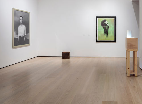 Installation view of four works, including a cube on the floor