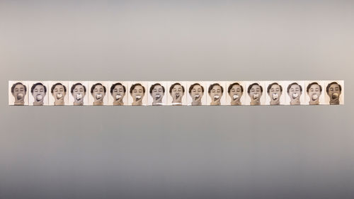 An array of black and white photos of the artist eating an apple