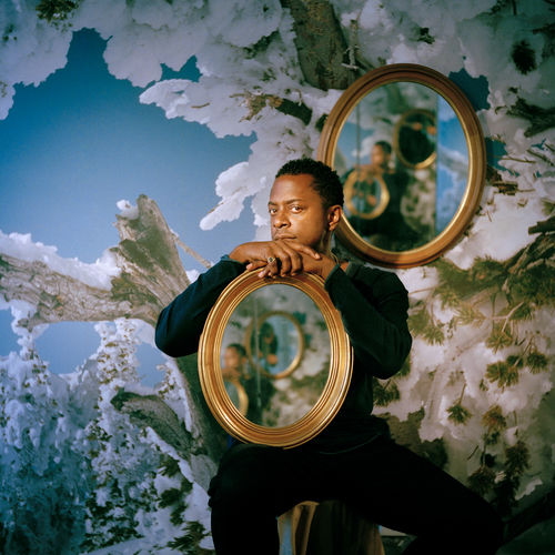 Sanford Biggers, holding a mirror in his lap