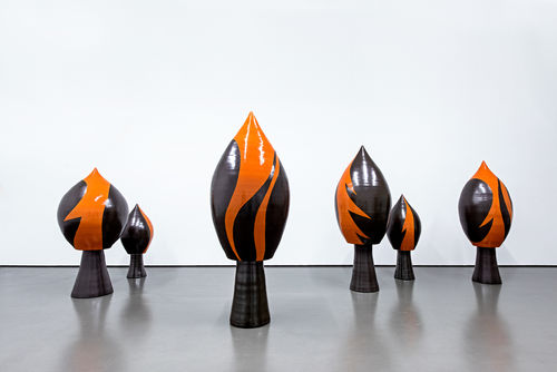 Six earthenware sculptures, in black and orange, in the shape of a spade