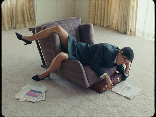A woman sits on a chair tipped on its side
