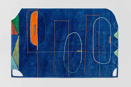 Colorful woven abstract tapestry on artificial turf