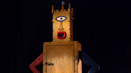 A wooden figure with one eye and open mouth