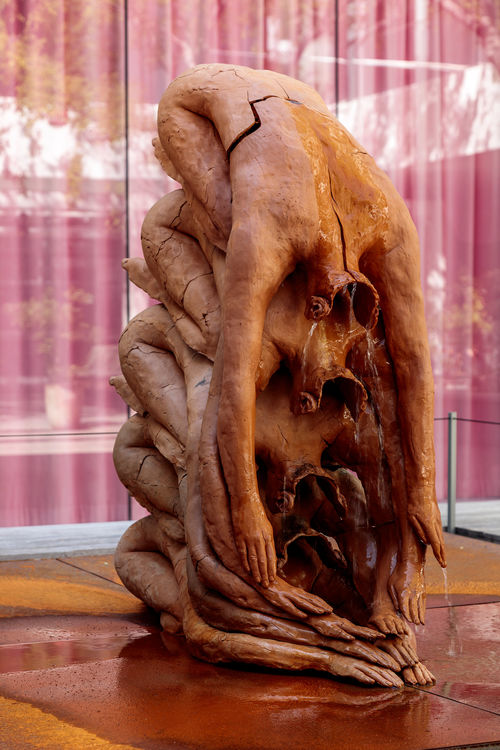 Sculptural fountain in the shape of the artist's prostrate body, stacked upon itself five times