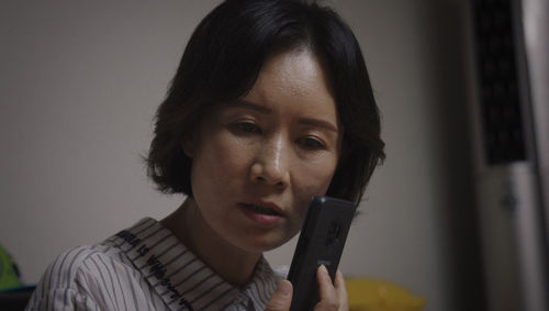 A Korean Woman holds her phone to her ear