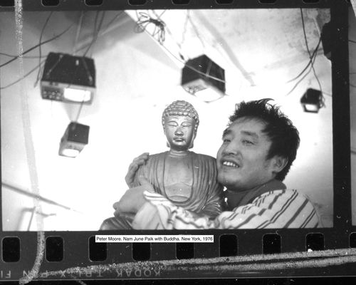 Nam June Paik embracing a buddha statue
