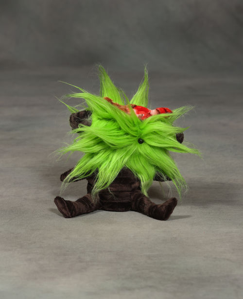 A brown plush object with green hair covering its head and face