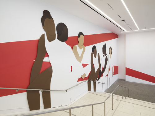 Hammer lobby wall installation depicting a group of abstracted figures, young gymnasts in leotards and high buns, which red architectural lines painted on white