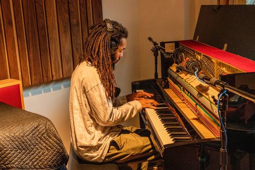 Musician Jamael Dean sits at a piano