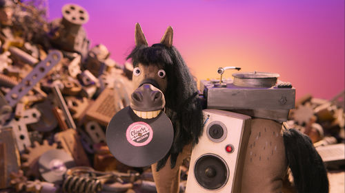 Animation still of a horse with a vinyl record in its mouth