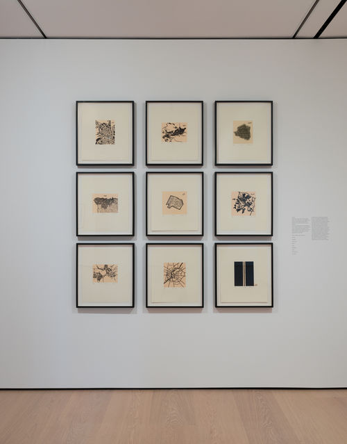 installation image of works on paper framed on walls