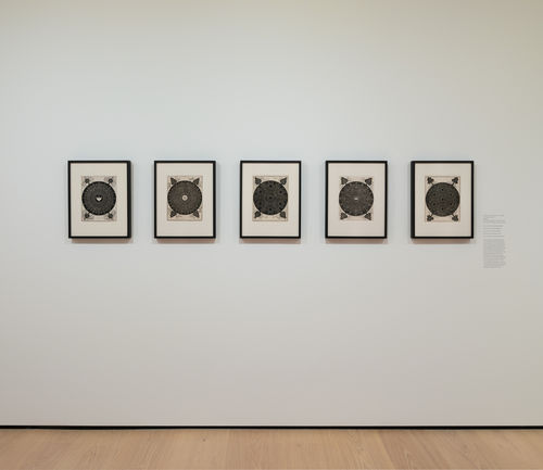 installation image of works on paper framed on walls