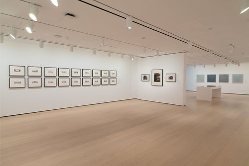 installation image of works on paper framed on walls