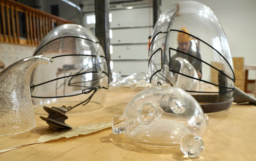 Blown glass shapes, through which is visible a distorted view of the artist