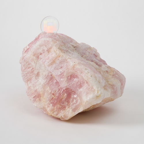 A large pink quartz with a disc-shaped memory crystal embedded in its top
