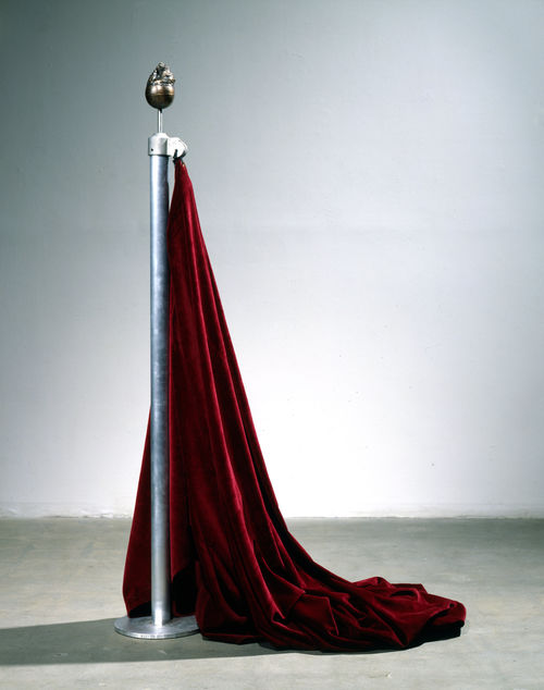Red theater curtain hanging from a flagpole topped with a sculpted bronze orb