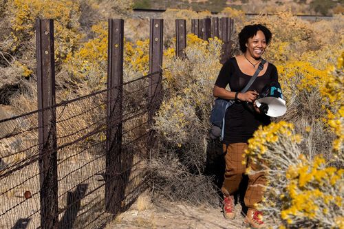 Krystle Hickman stands in a nature preserve holding a camera