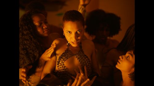 A group of female figures in soft warm lighting