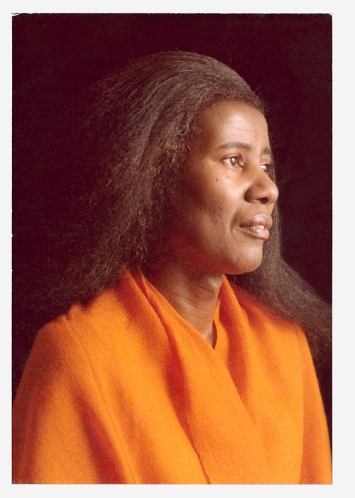 Color photograph of Alice Coltrane wearing an orange garment