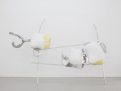 A large sculpture with metal bars leaning against the wall