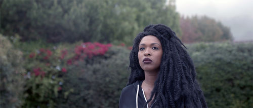 Film still of a Black woman with braids