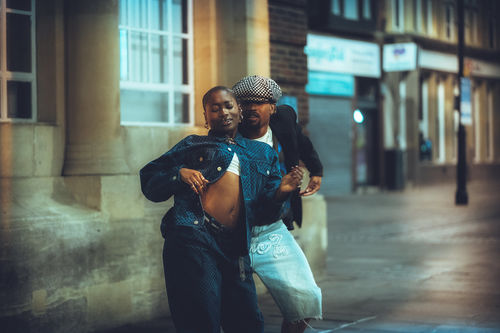 A man and woman dance on the sidewalk