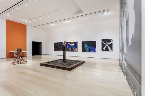 Installation view of an exhibition gallery with orange walls