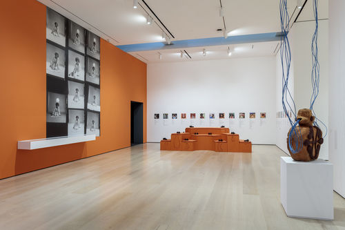 Installation view of an exhibition gallery with orange walls