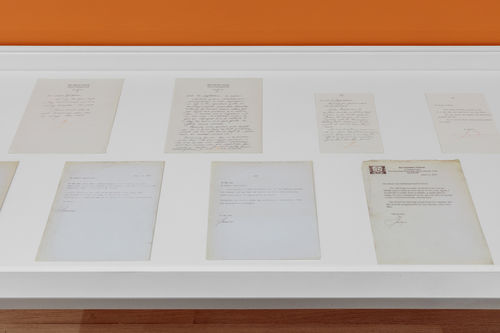 Installation view of a vitrine full of handwritten correspondence