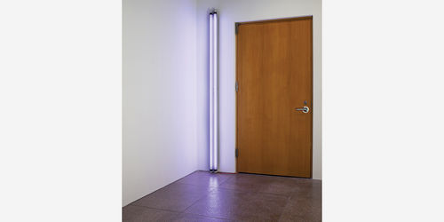 A photo of a door with a purple fluorescent light beside it