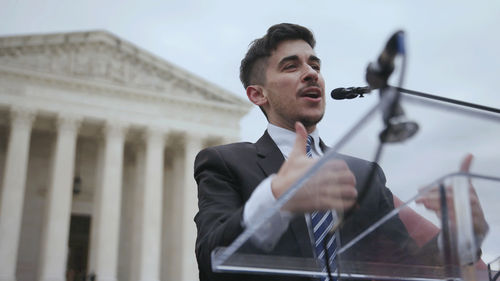 Chase Strangio speaks in front of the Capitol Building