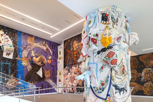 View of a museum lobby, walls covered in colorful murals