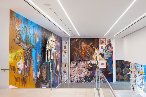 View of a museum lobby, walls covered in colorful murals